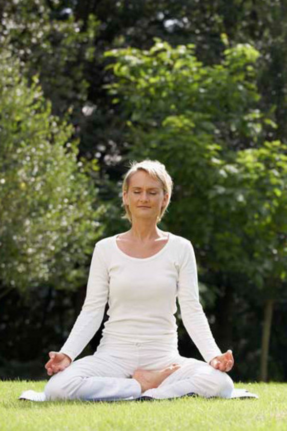 Frau meditiert mit geschlossenen Augen auf Wiese - Immanuel Ayurveda Zentrum Frau meditiert mit geschlossenen Augen auf Wiese - Immanuel Ayurveda Zentrum